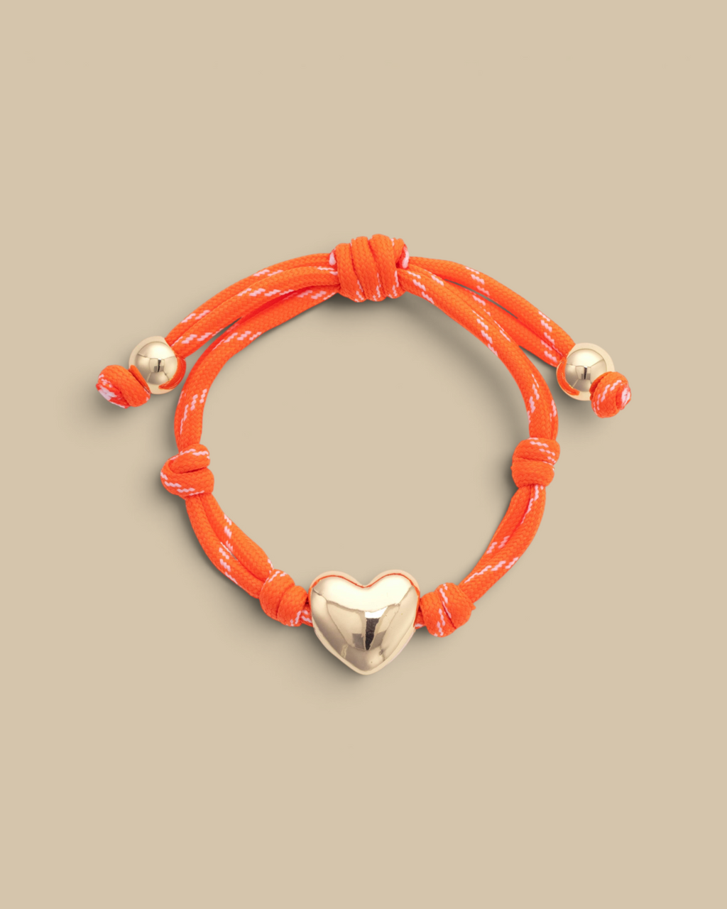 Homestyle Collective orange paracord bracelet featuring a glossy gold puffy heart charm and adjustable knot details.
