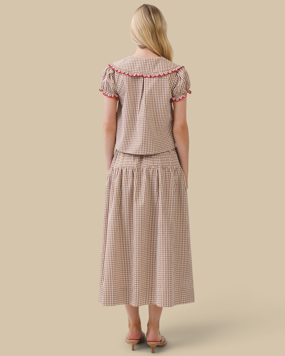 Back view of Homestyle Collective gingham two-piece set with Peter Pan collar, puff sleeves, and red scalloped trim.