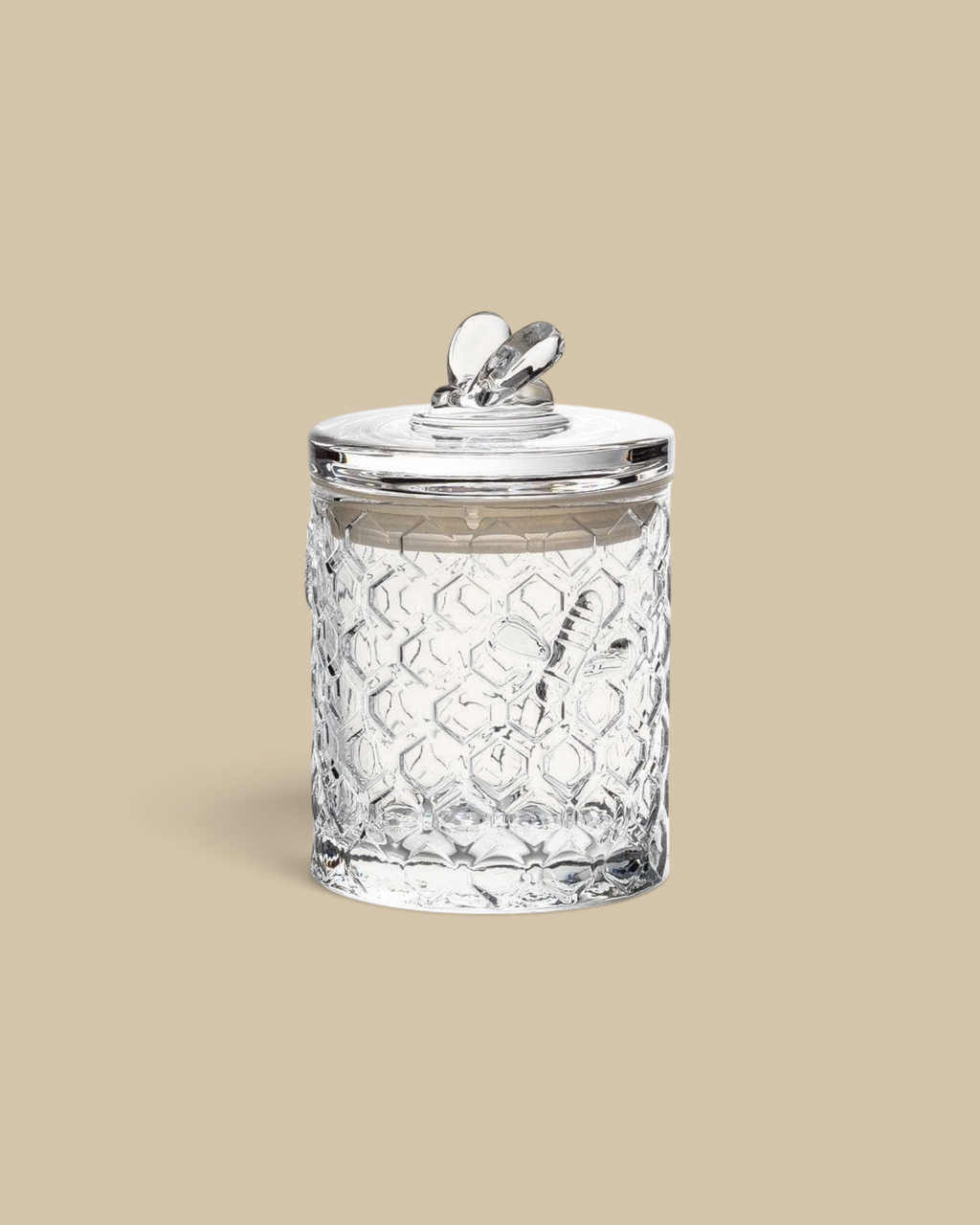 Homestyle Collective clear glass honeycomb textured jar with a decorative bee on the lid and silicone seal