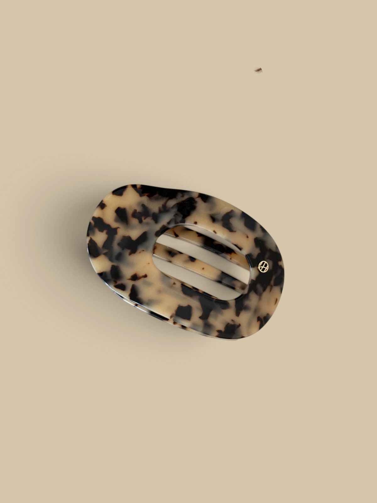 Homestyle Collective oval hair claw clip in a tortoise-shell acetate pattern with a hollow-out design.