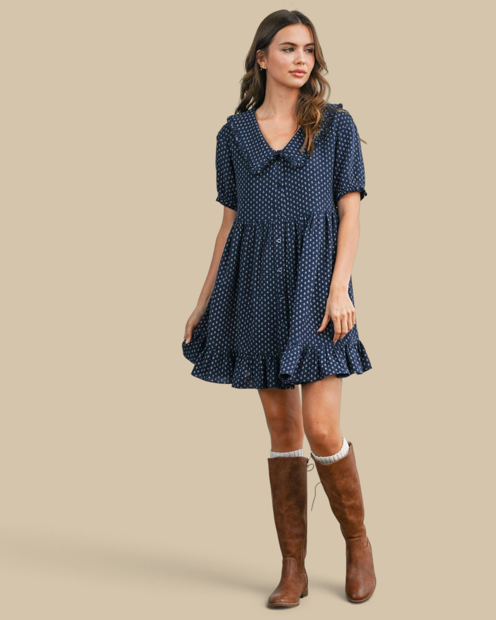 Homestyle Collective navy puff-sleeve mini dress with a peter pan collar, button front, and ruffled hem on a model.