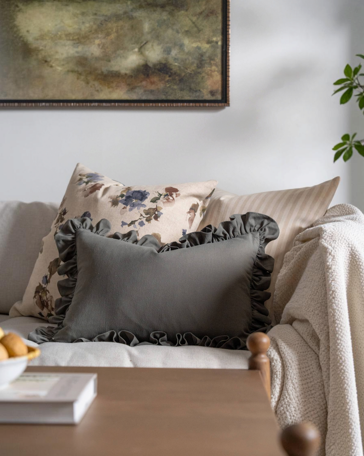 Homestyle Collective green sand-wash cotton lumbar pillow cover with decorative ruffles on a neutral sofa