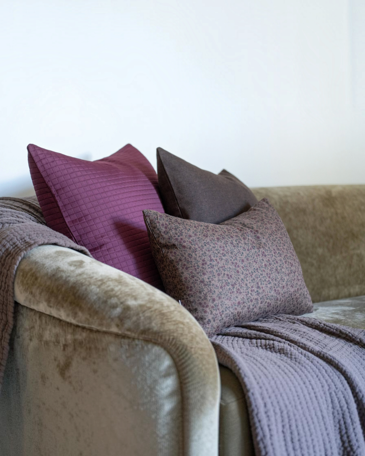 Homestyle Collective Trudie floral linen pillow cover in brown, burgundy, and green on a sofa with a brass zipper.