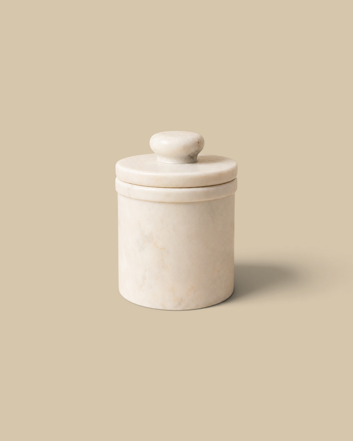 Homestyle Collective white marble butter keeper with a lid, featuring a classic cylindrical design for kitchen use.