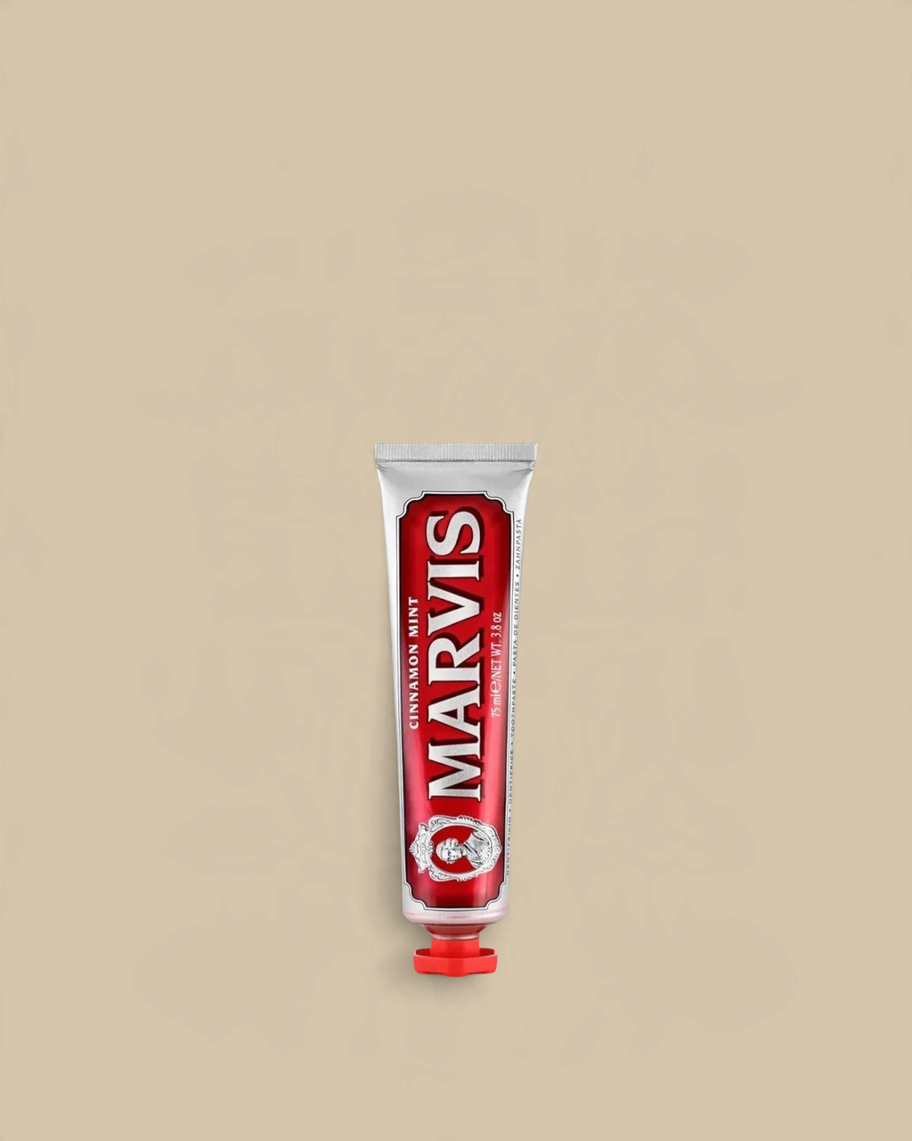 Homestyle Collective Marvis Cinnamon Mint toothpaste in a classic red travel-sized metal tube on a beige background.