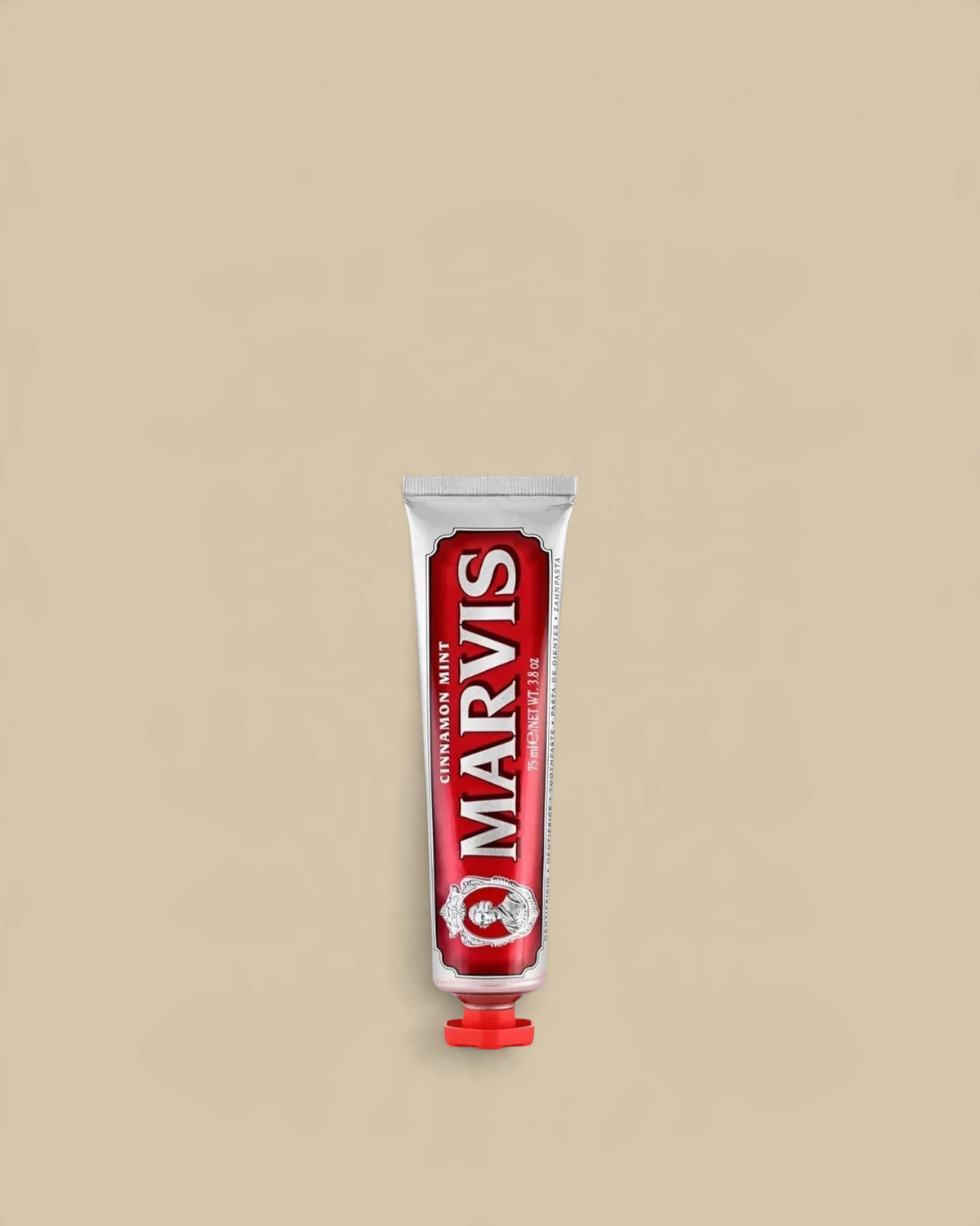Homestyle Collective Marvis Cinnamon Mint toothpaste in a classic red travel-sized metal tube on a beige background.