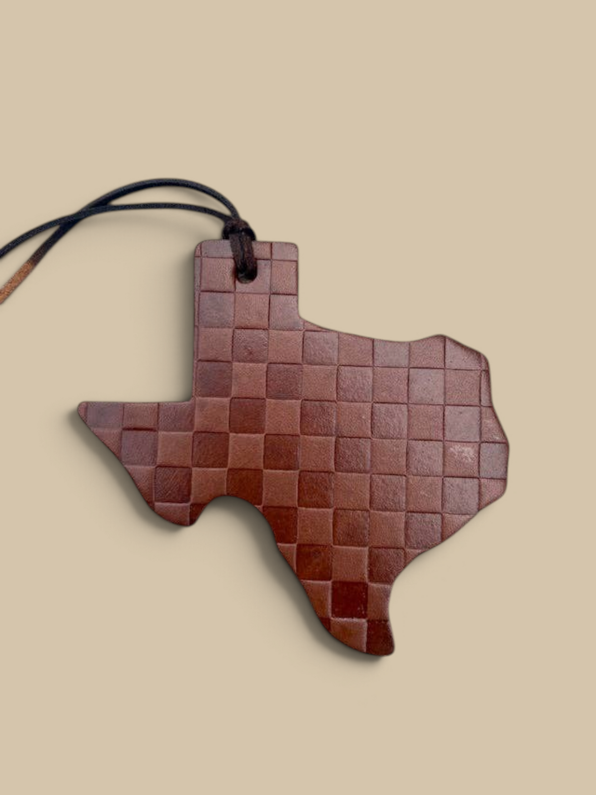 Homestyle Collective leather air freshener in a Texas state shape with a brown checkered pattern and hanging cord.