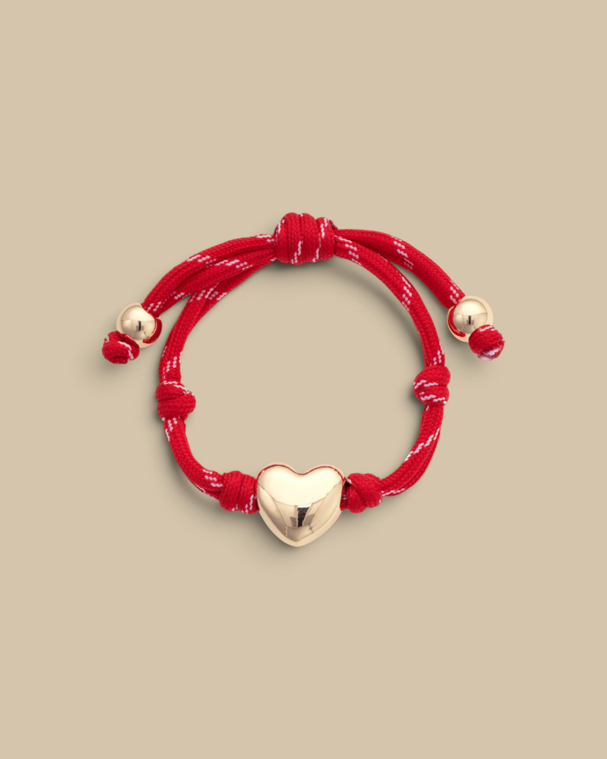 Homestyle Collective red paracord bracelet featuring a glossy gold puffy heart charm and adjustable knot closure.