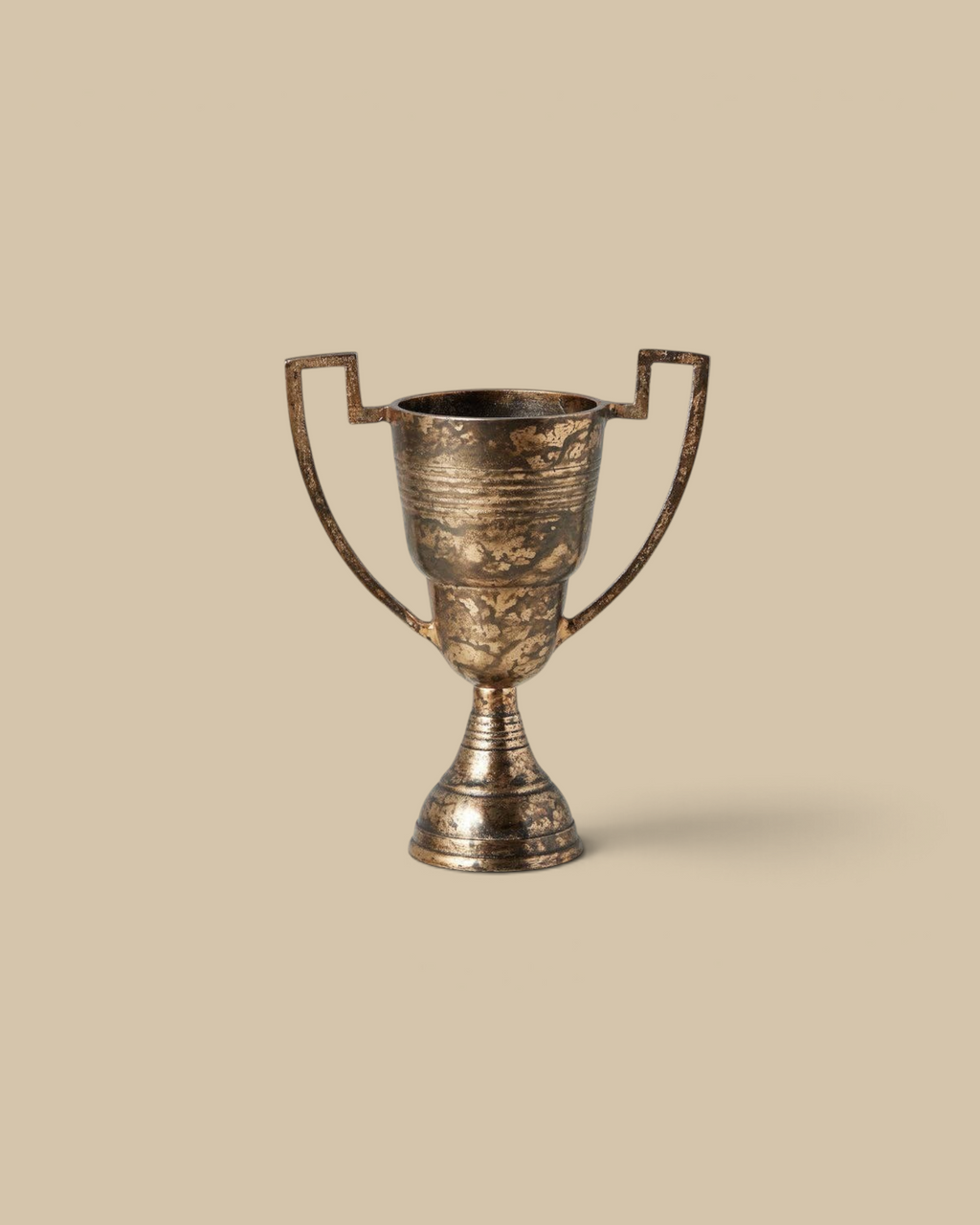 Homestyle Collective distressed gold metal trophy cup with vintage-inspired silhouette for decorative shelf display