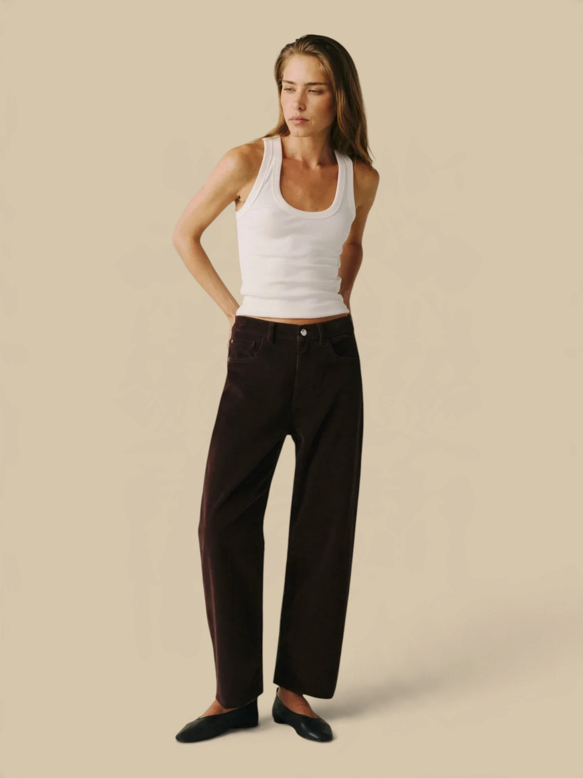 Model wearing Homestyle Collective BNA soft curve barrel jeans in Americano brown corduroy with a white tank top