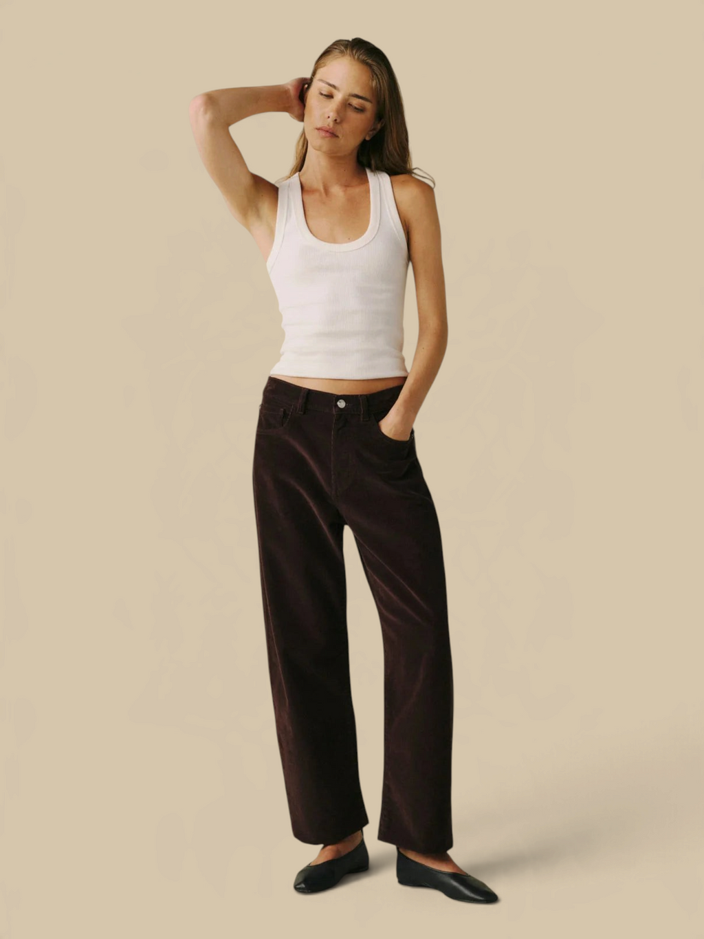 Model wearing Homestyle Collective BNA soft curve barrel jeans in Americano brown corduroy with a white tank top