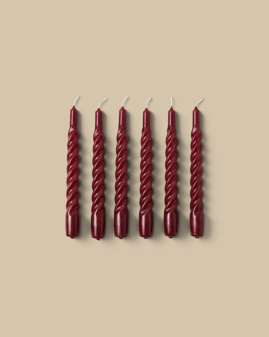 Homestyle Collective set of six merlot lacquered twisted taper candles made from premium soy wax on marble surface