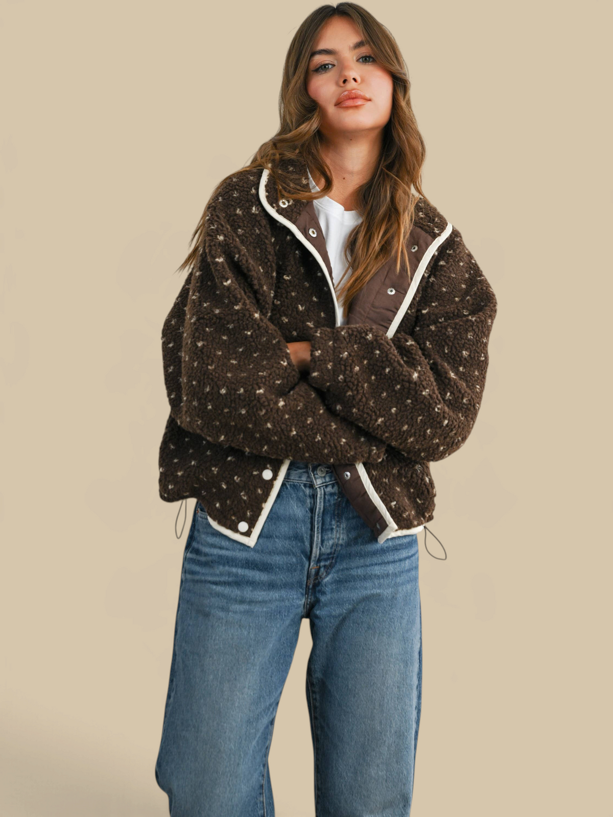 Model wearing a Homestyle Collective brown high pile fleece puffer jacket with white trim and snap button closure.