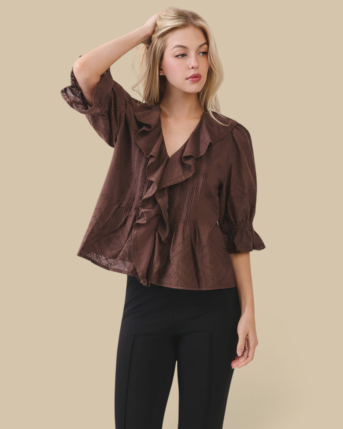 Homestyle Collective brown cotton eyelet blouse with ruffle front, pintuck pleating, and volume sleeves on a model