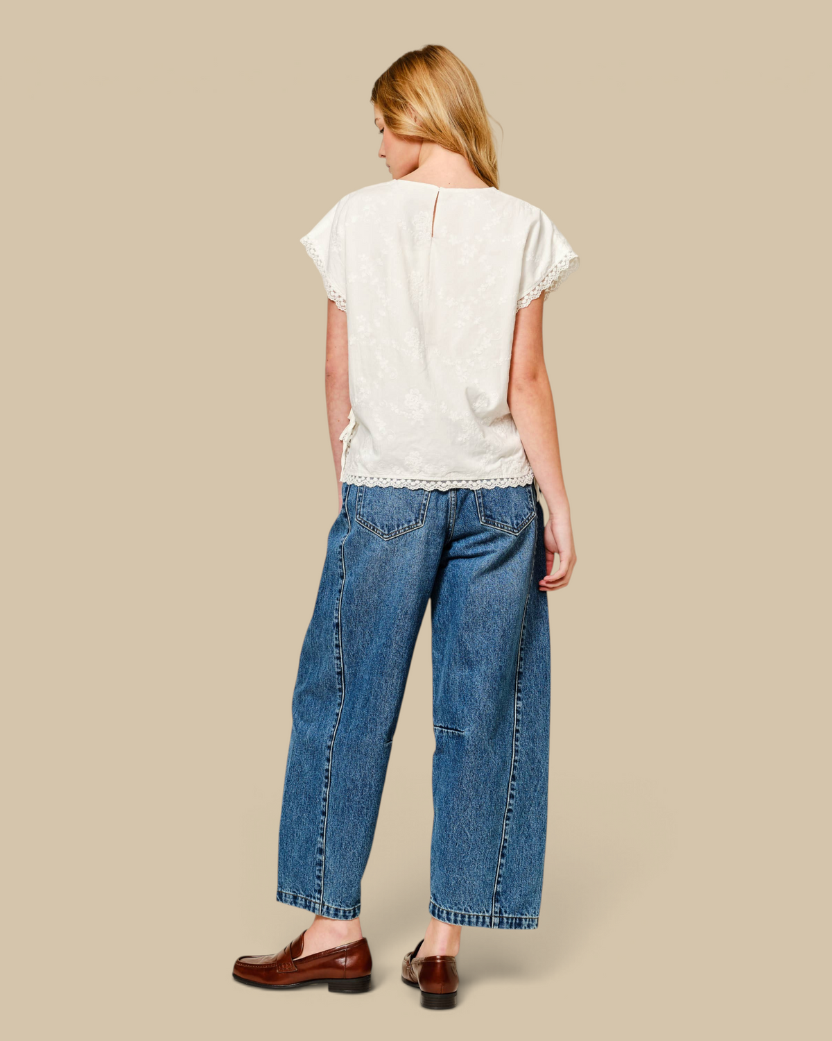 Homestyle Collective cropped denim barrel jeans with a mid-rise waist and curved leg, worn with a white lace top.