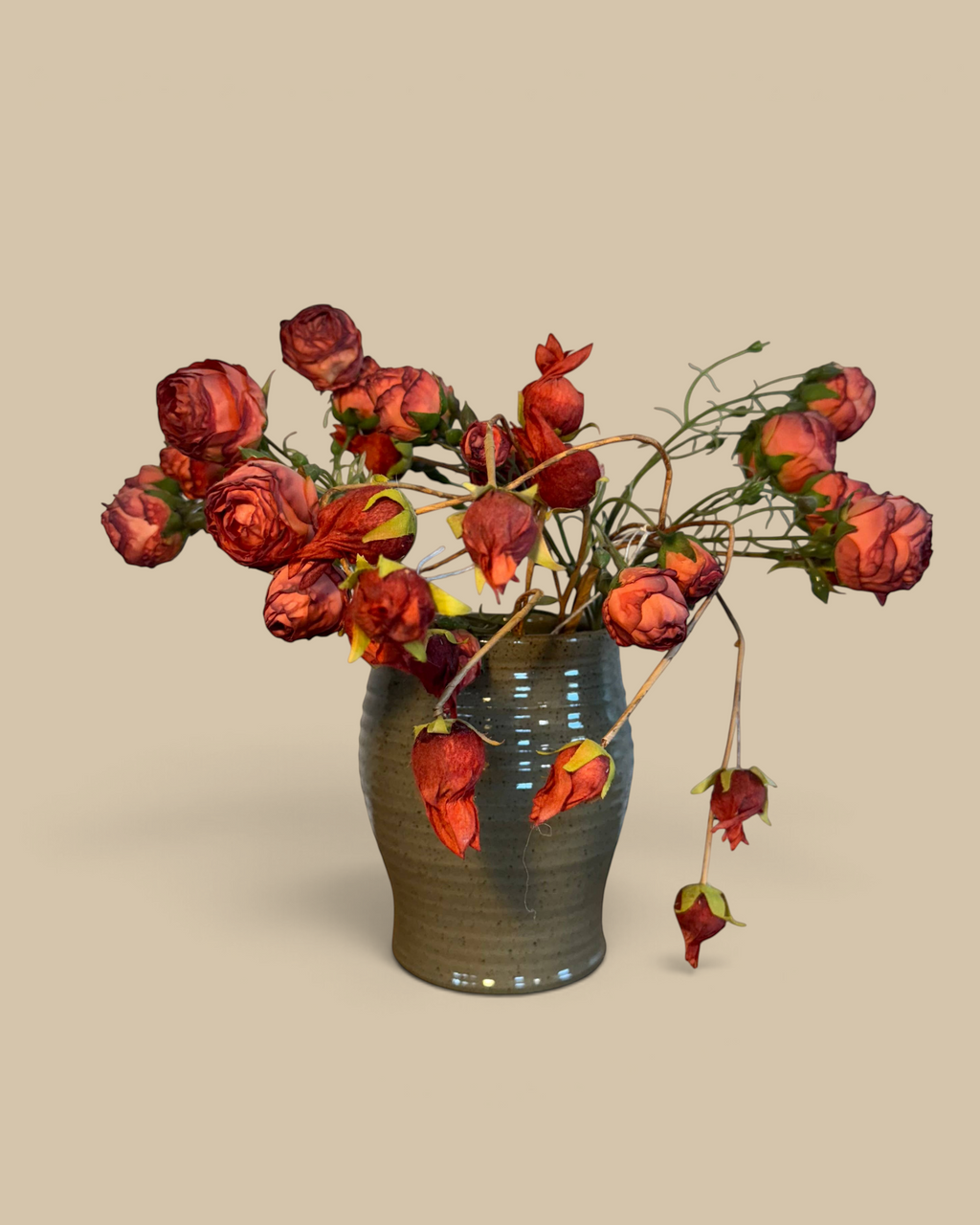 Homestyle Collective mocha glazed ceramic utensil jar filled with dried red roses on a burlap surface