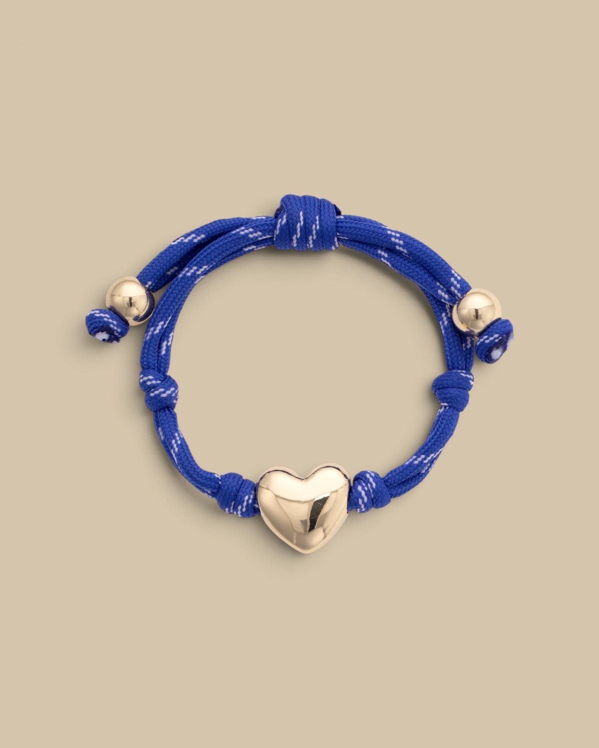 Homestyle Collective blue paracord bracelet featuring a glossy gold puffy heart charm and metallic bead accents.