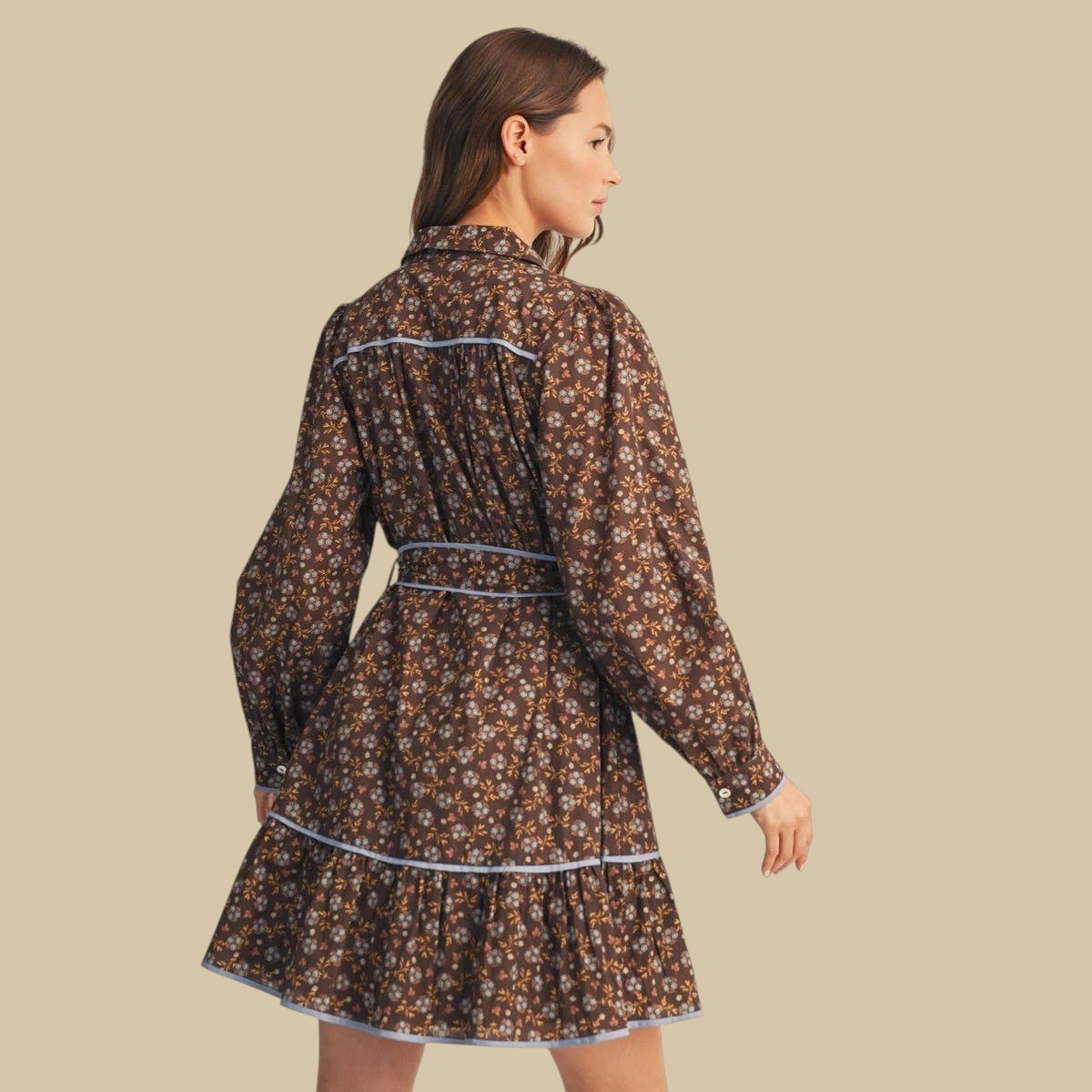 Homestyle Collective brown floral cotton dress with long sleeves, waist tie, and blue piping, back view.