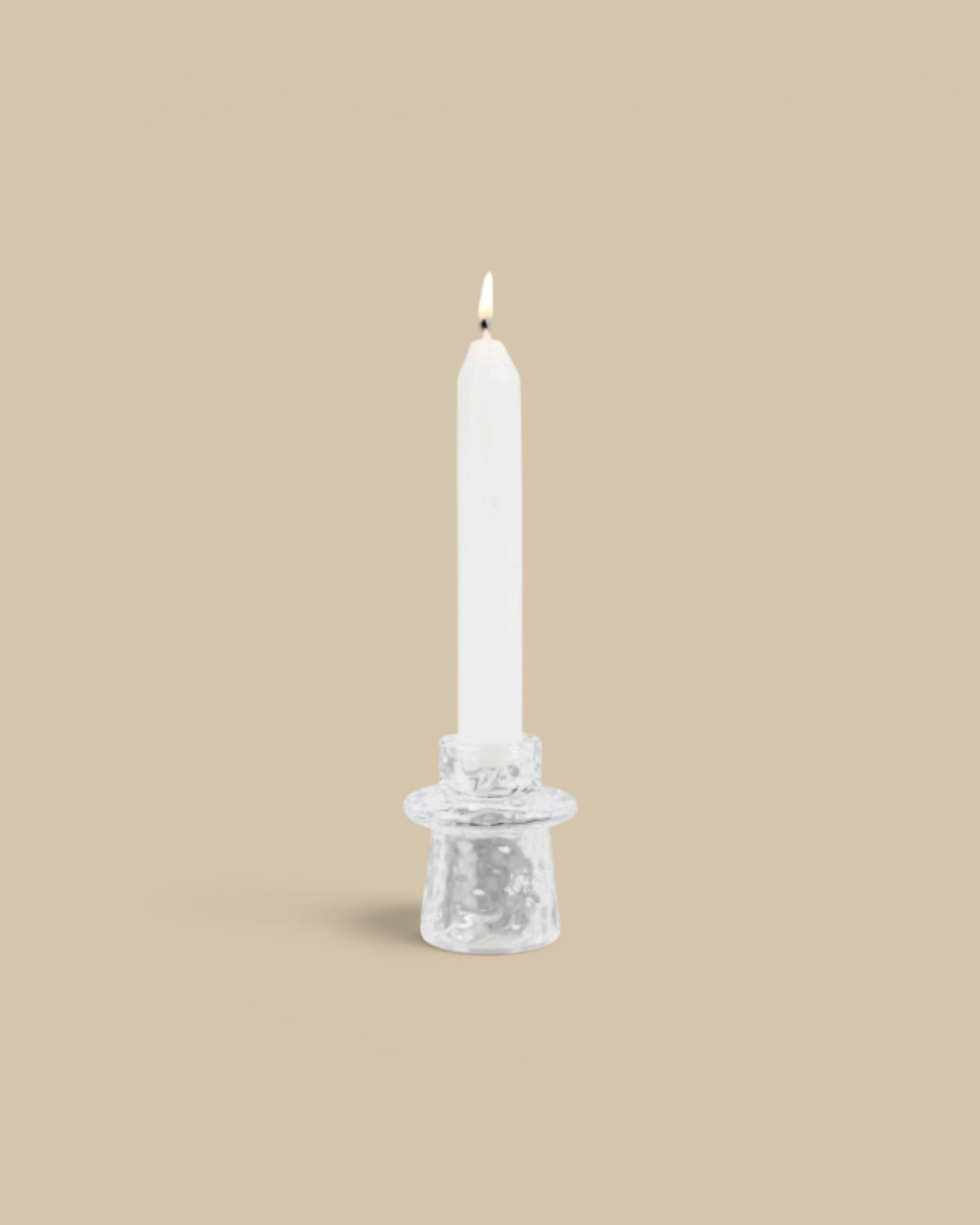 Homestyle Collective organic clear pressed glass taper candle holder with a lit white candle