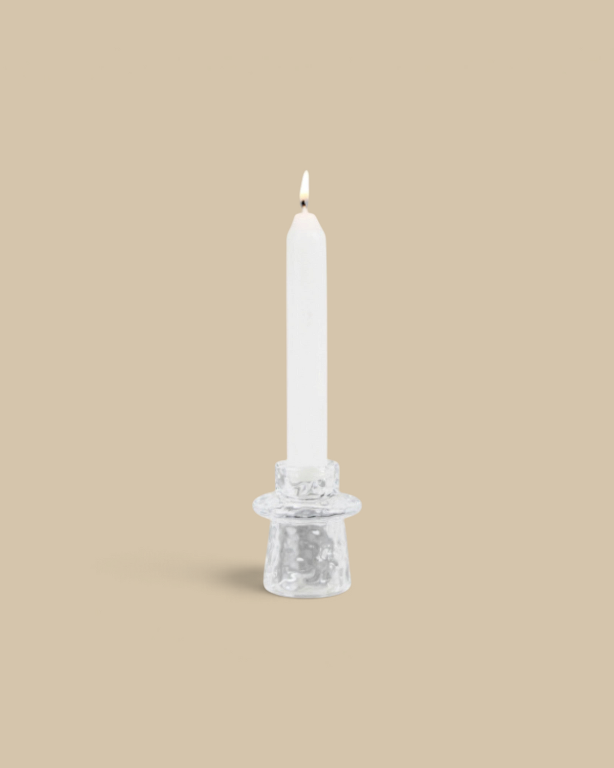 Homestyle Collective organic clear pressed glass taper candle holder with a lit white candle