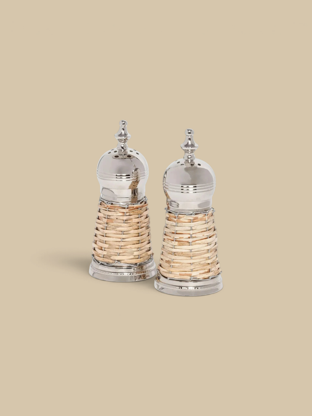 Homestyle Collective Cap Ferrat salt and pepper shakers with polished metal tops and handwoven natural rattan bases.