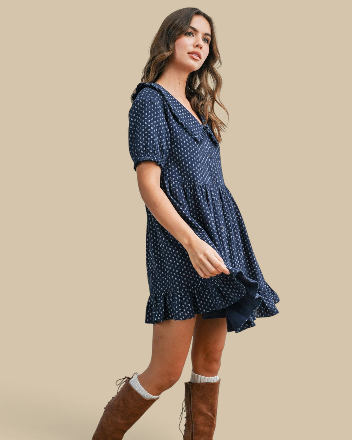 Homestyle Collective navy mini dress with puff sleeves, ruffled hem, and white floral print worn with brown boots.