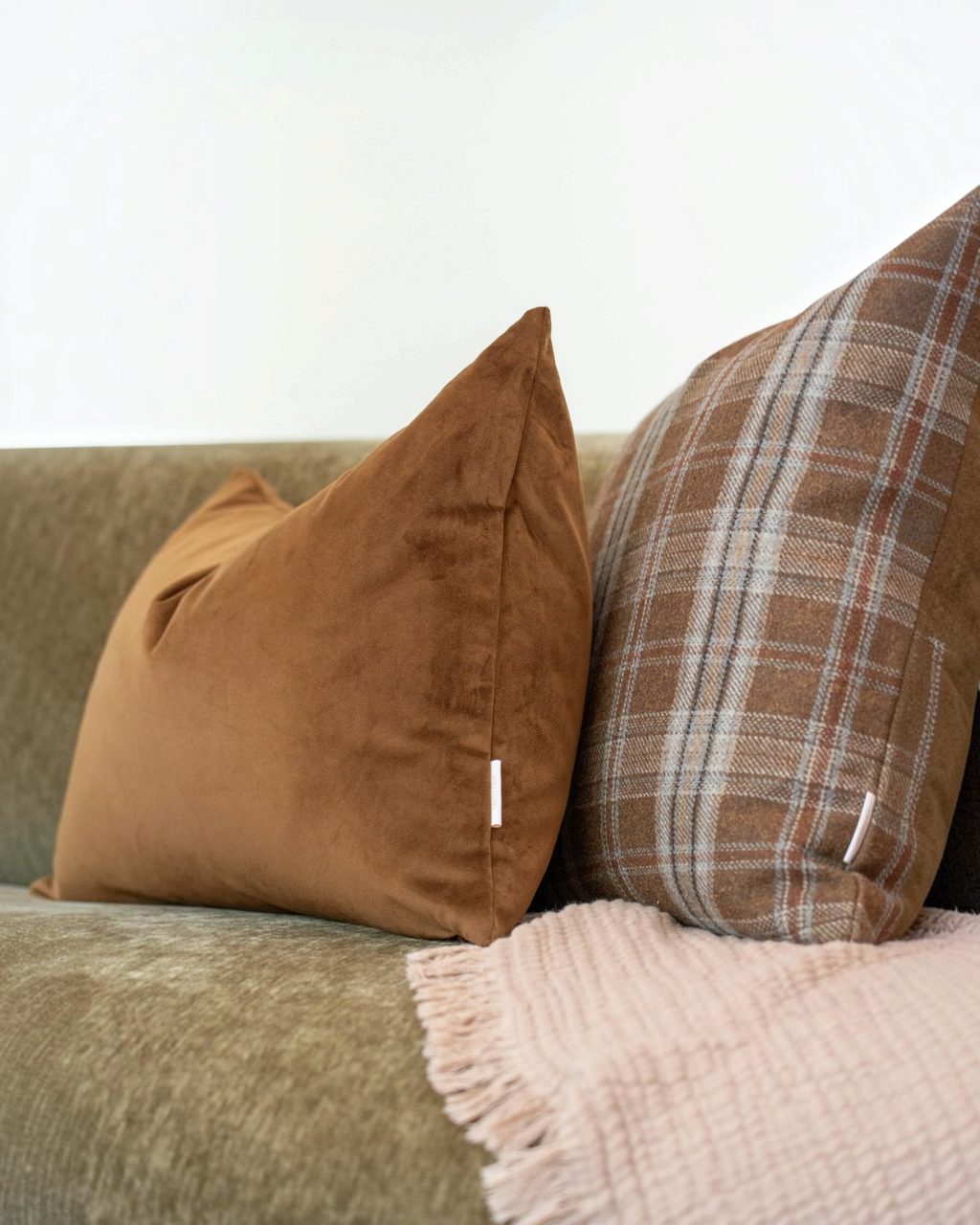 Homestyle Collective Thatcher plaid wool-blend pillow cover in brown and blue tones resting on a sofa.