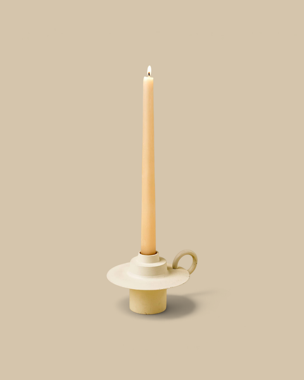 Homestyle Collective ivory aluminum Foundry candle holder with a looped handle and a lit tapered candle