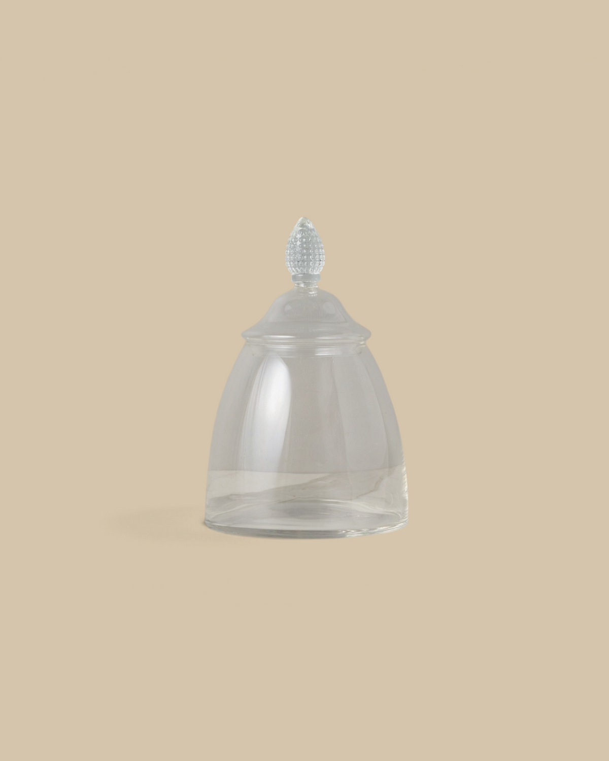 Homestyle Collective glass teardrop jar with a decorative finial lid, displayed on a white marble surface.