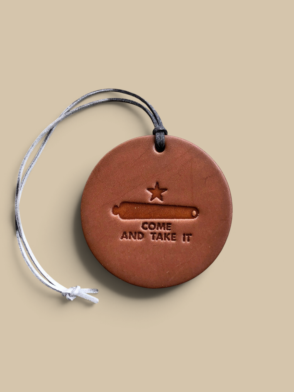 Homestyle Collective round leather air freshener with a cannon and star stamp and Come and Take It text