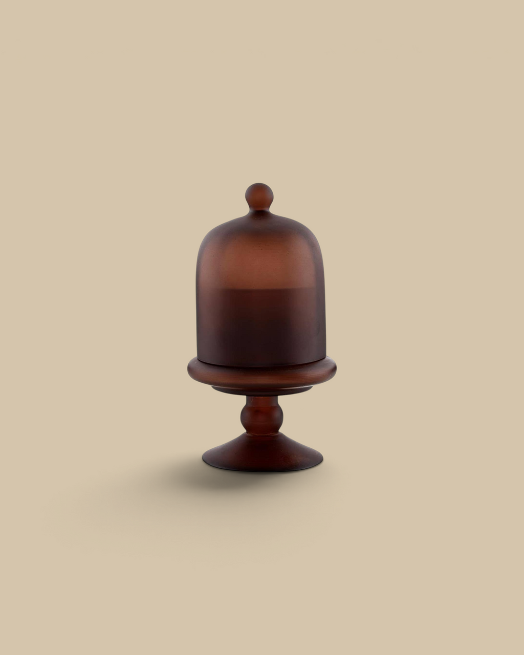 Homestyle Collective brown cloche candle in a smoky amber glass bell jar with a pedestal base and removable lid.
