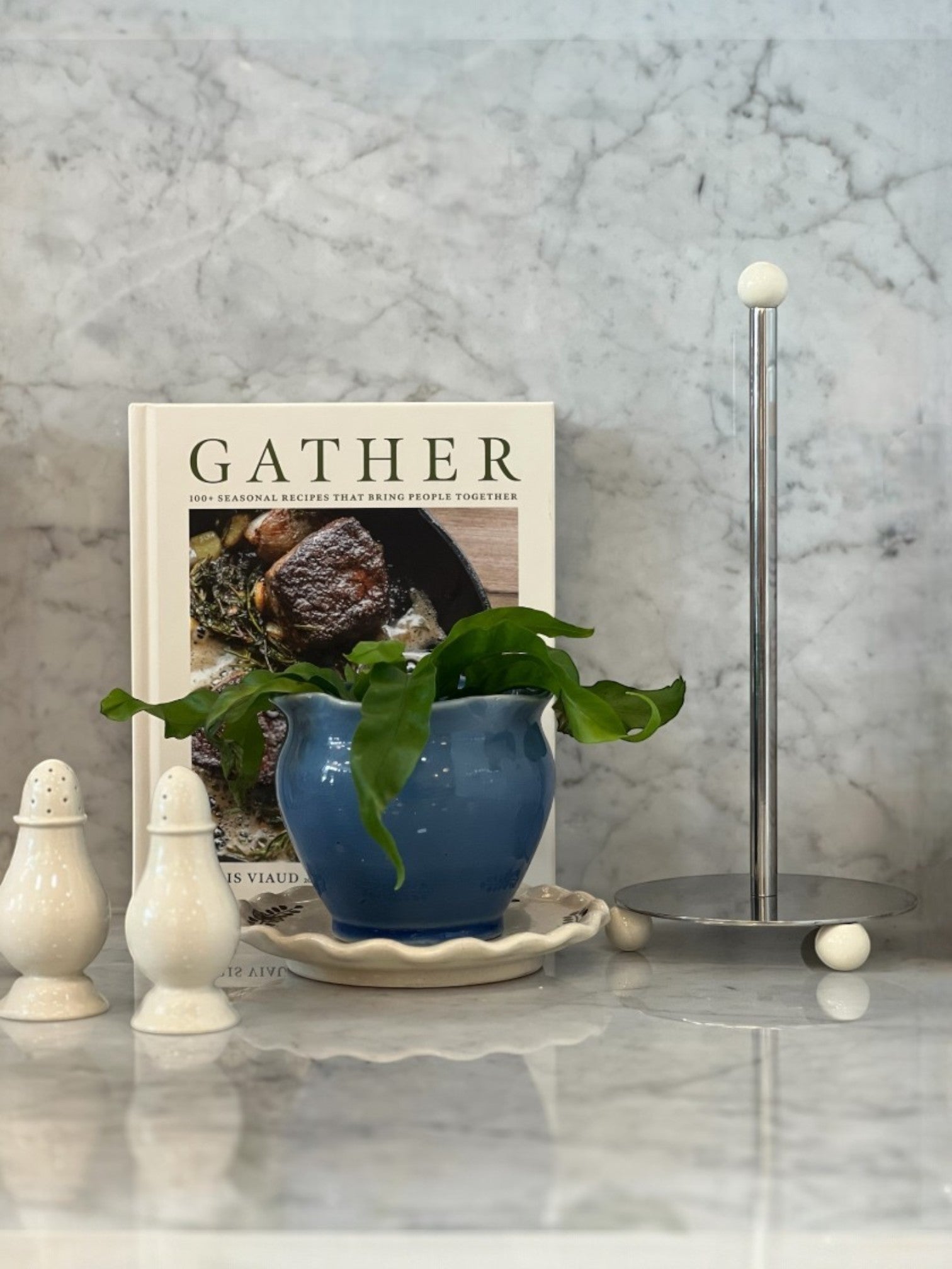 Homestyle Collective Axis Stainless Steel Nickel Finish Paper Towel Holder with white enameled ball feet and top finial.
