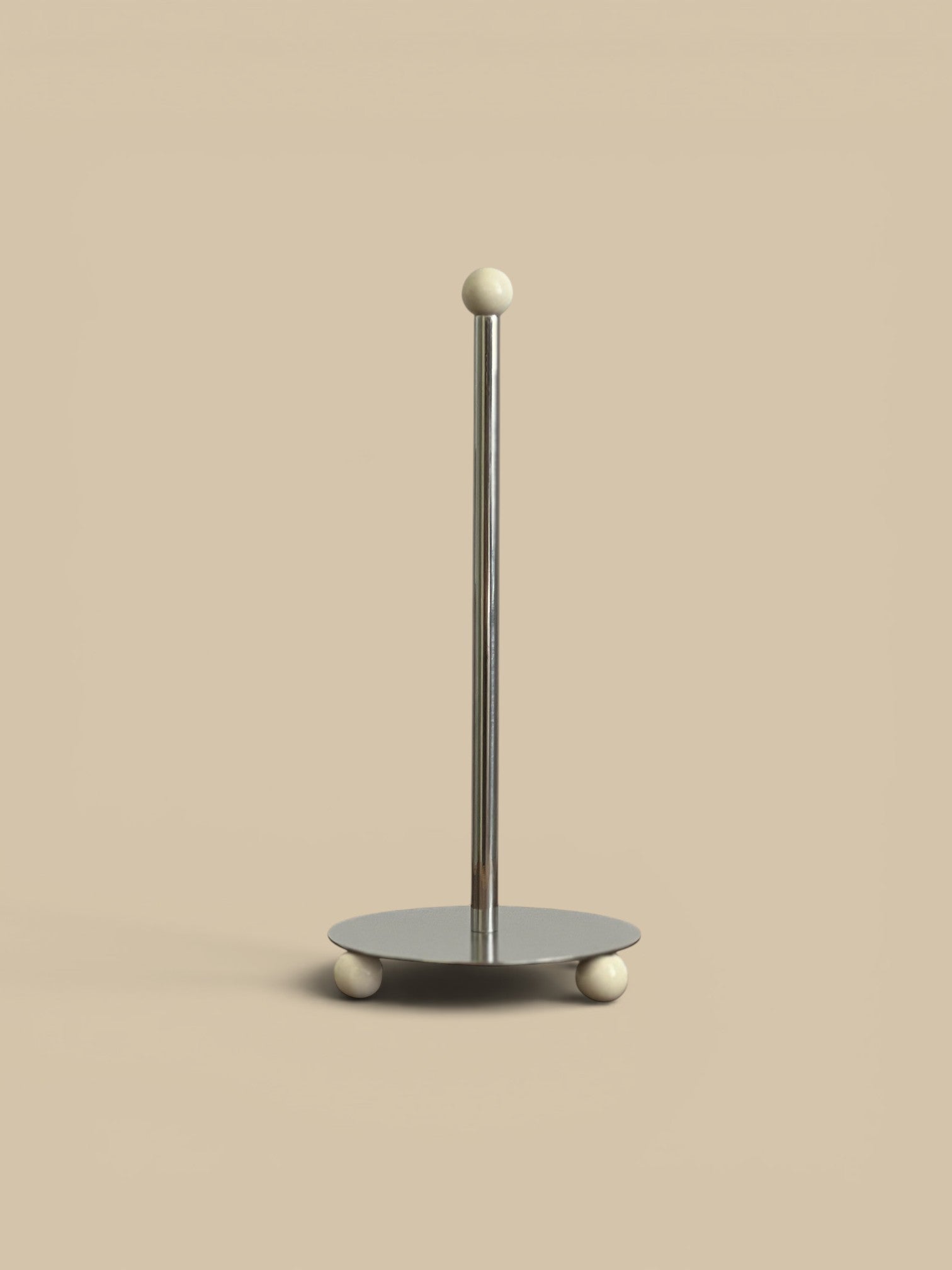Homestyle Collective Axis Stainless Steel Paper Towel Holder with cream ball feet and finial.