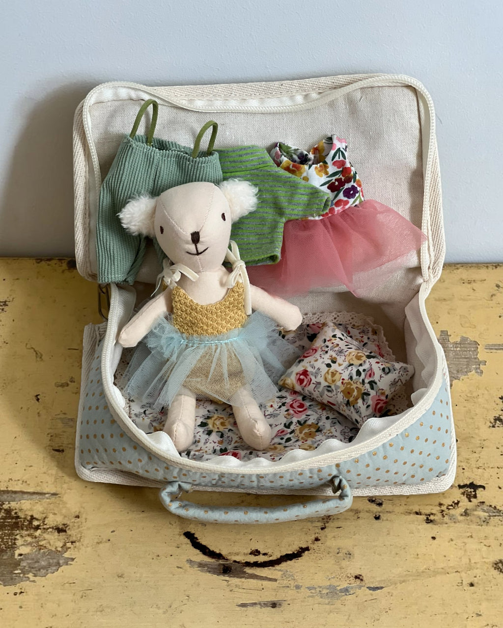 Homestyle Collective fabric suitcase playset featuring a stuffed bear doll with tiny outfits and a floral pillow.