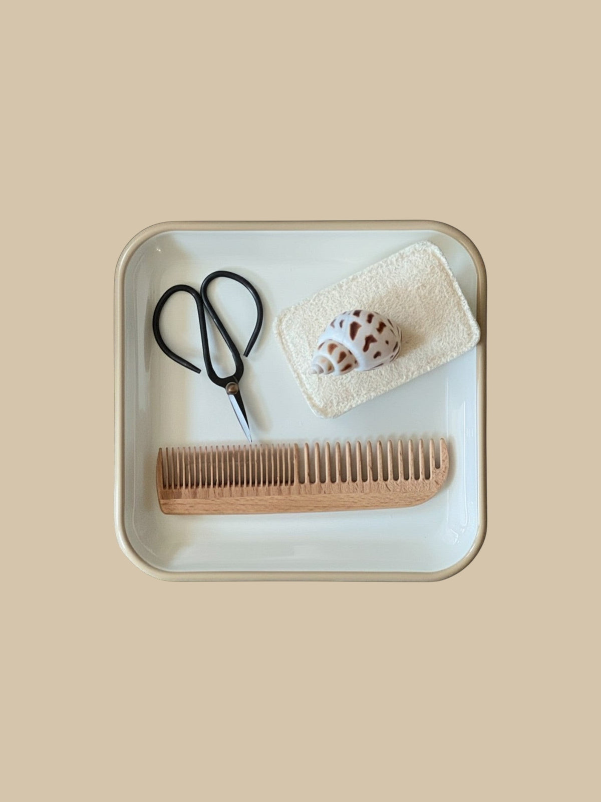 Homestyle Collective 7-inch beechwood comb with dual-sided teeth, displayed on a tray with scissors and a seashell.