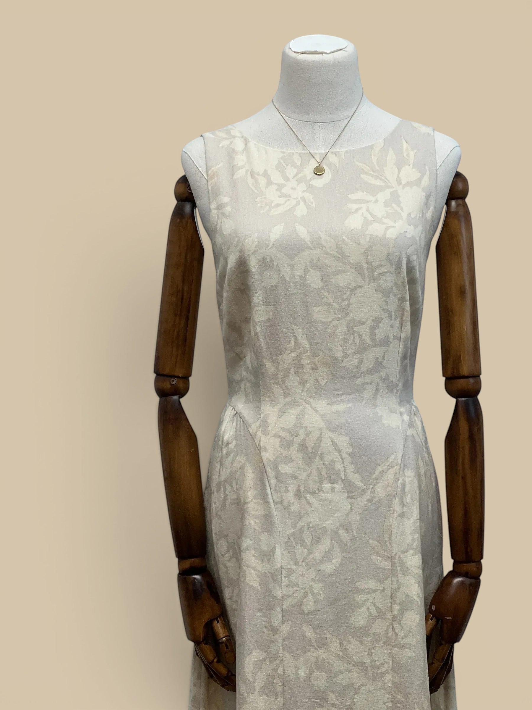 Homestyle Collective beige linen Parker dress featuring a subtle tone-on-tone floral pattern and sleeveless design.