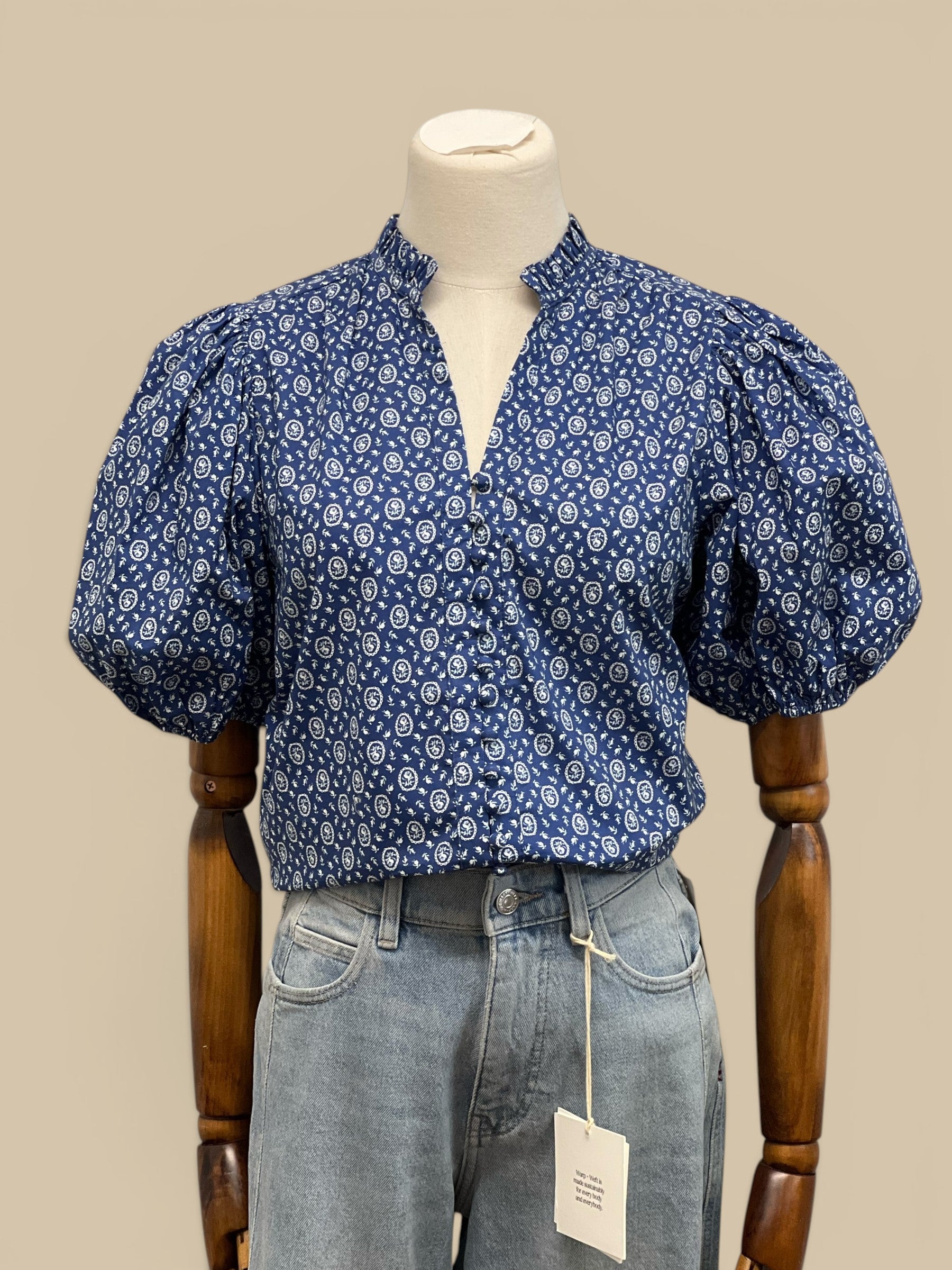 Homestyle Collective blue floral print blouse with ruffled V-neck, balloon sleeves, and elastic cuffs.