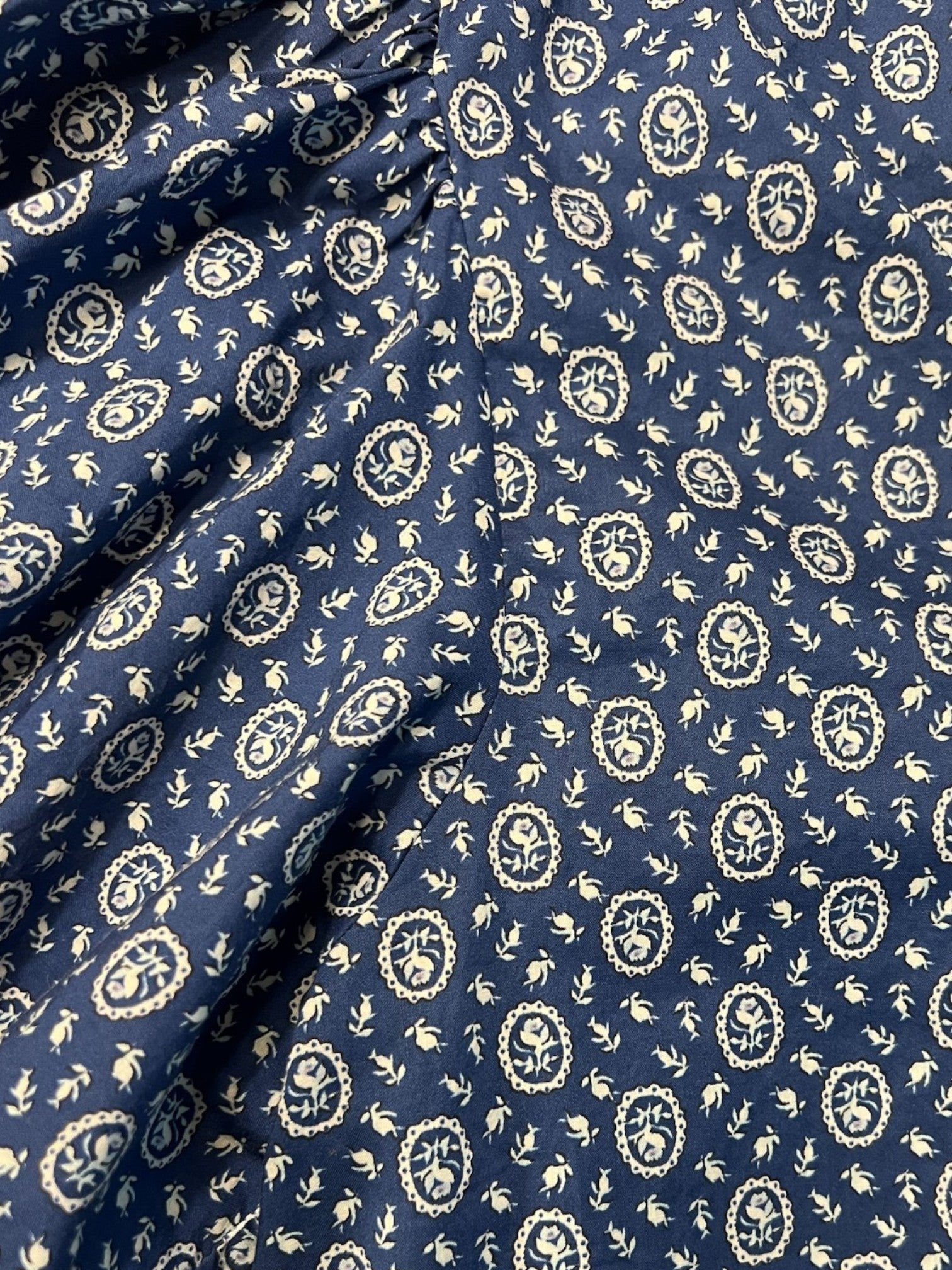 Homestyle Collective blue floral cameo blouse with ruffled neckline and balloon sleeves.