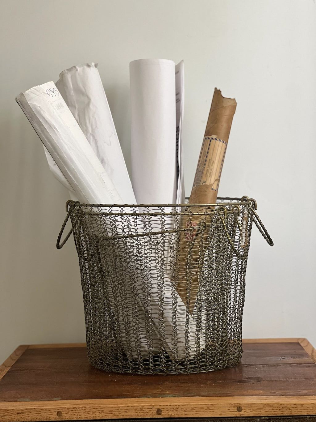 Homestyle Collective Moana brass wire basket with handles, holding rolled papers and documents. Set of 3.