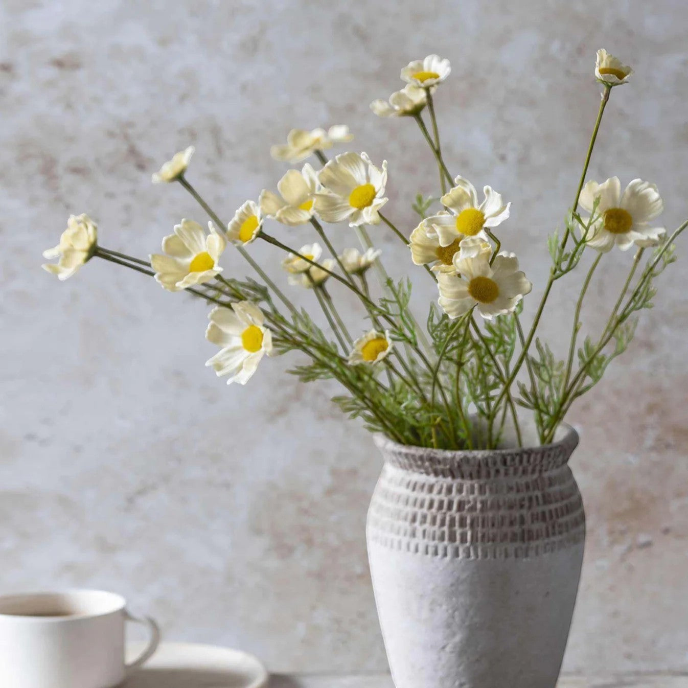 Homestyle Collective artificial cosmos meadow flowers in buttermilk hue with yellow centers and green stems.