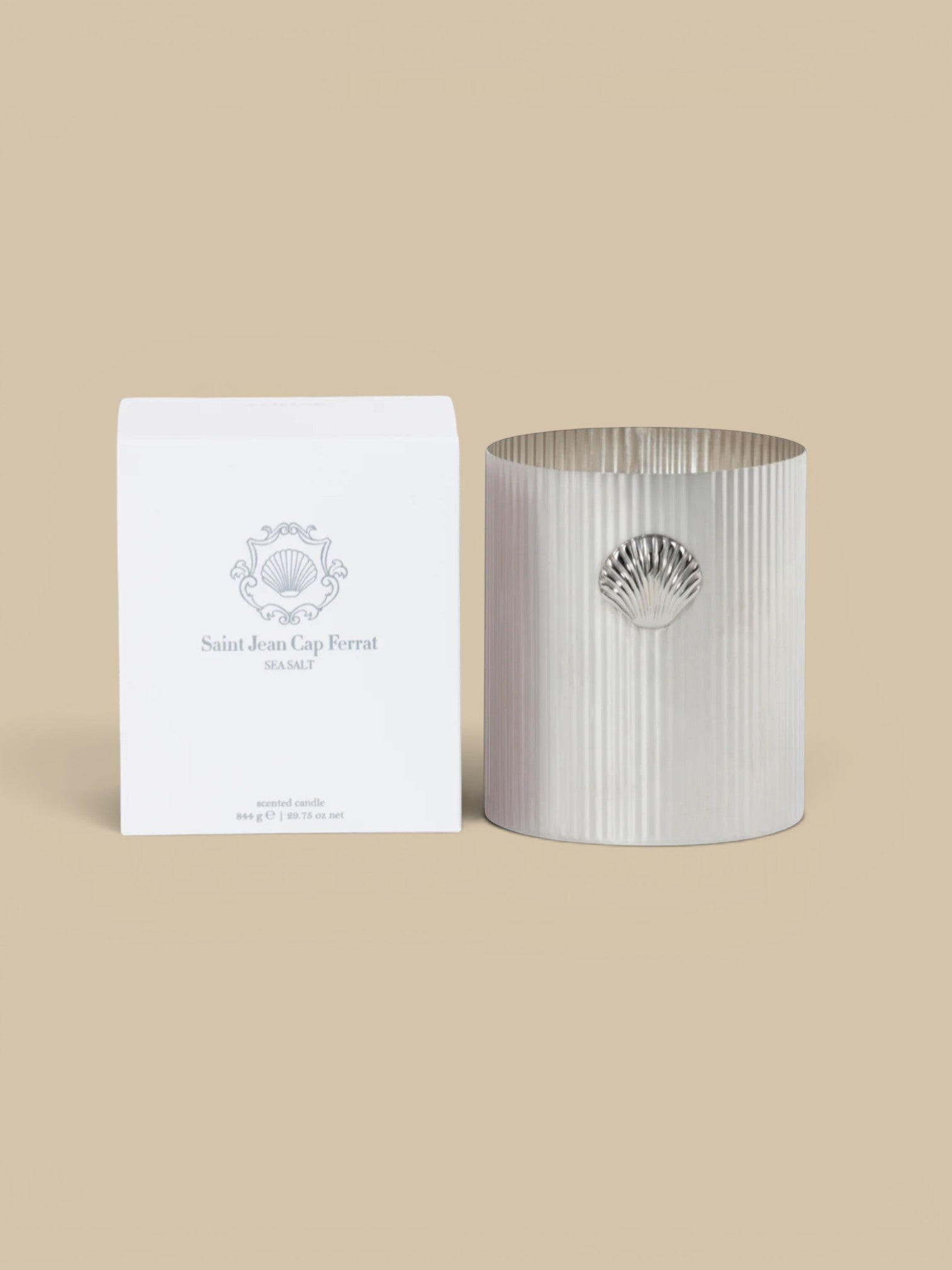 Homestyle Collective Cap Ferrat Sea Salt scented candle in a fluted silver metal holder with a shell accent.