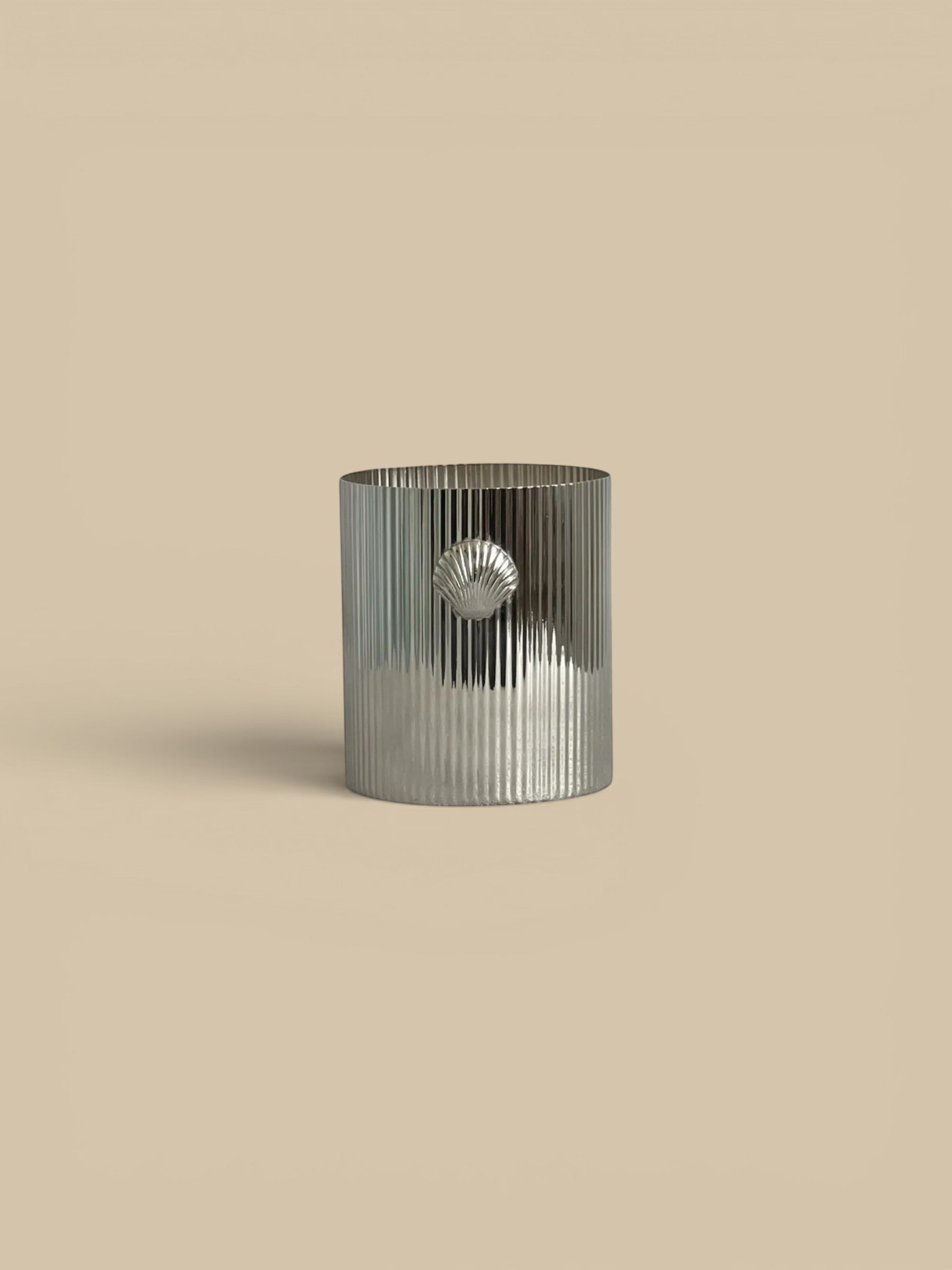 Homestyle Collective Cap Ferrat Shell Candle in Sea Salt scent. Silver ribbed vessel with a shell accent.