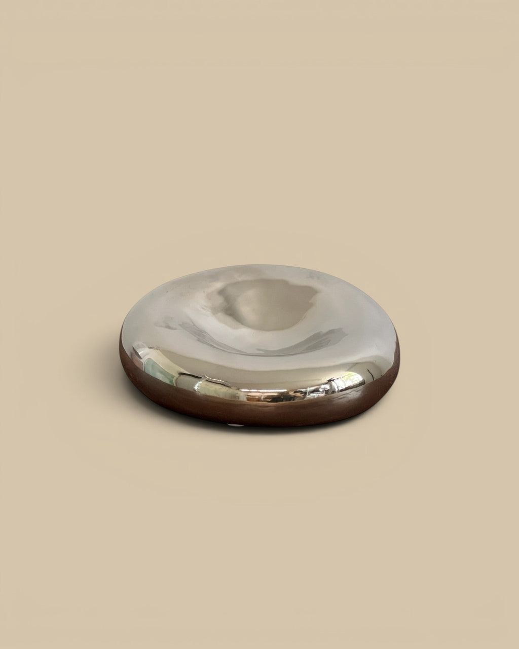 Homestyle Collective chrome glazed decorative bowl with a smooth, reflective surface and a dark base.