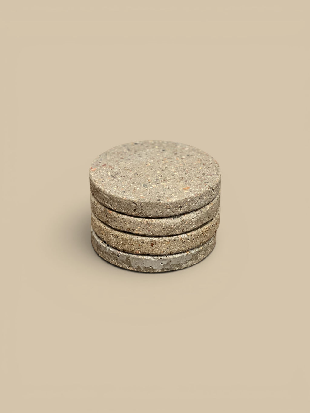 Homestyle Collective set of 4 round concrete drink coasters with speckled matte finish.