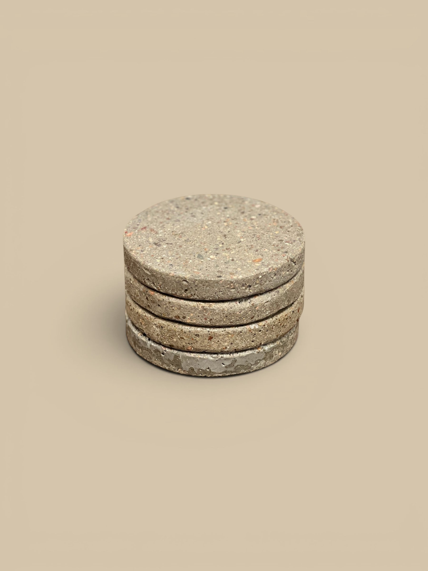 Homestyle Collective set of 4 round concrete drink coasters with speckled matte finish.