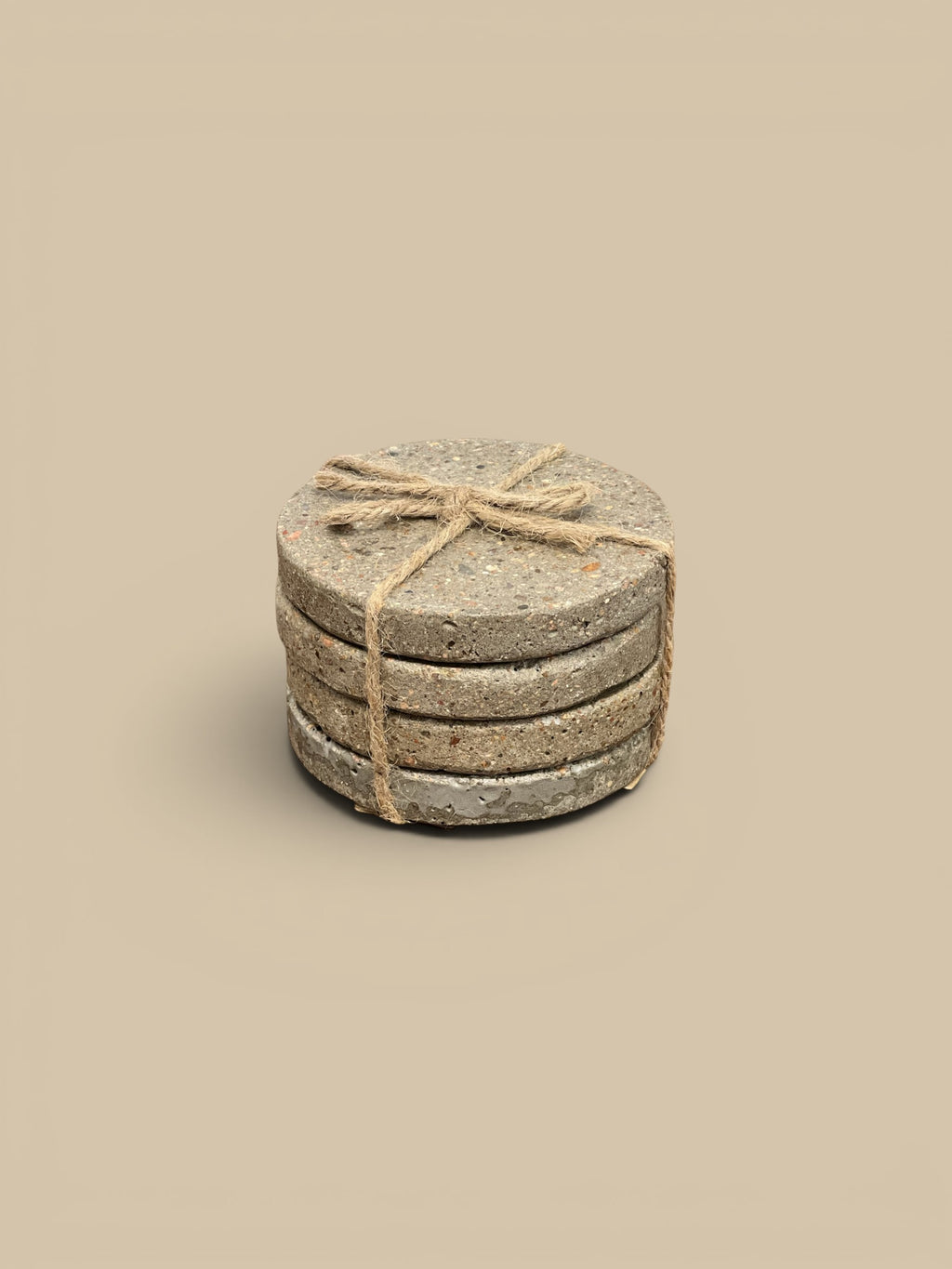 Homestyle Collective set of 4 round concrete coasters with a natural speckled finish, tied with twine.