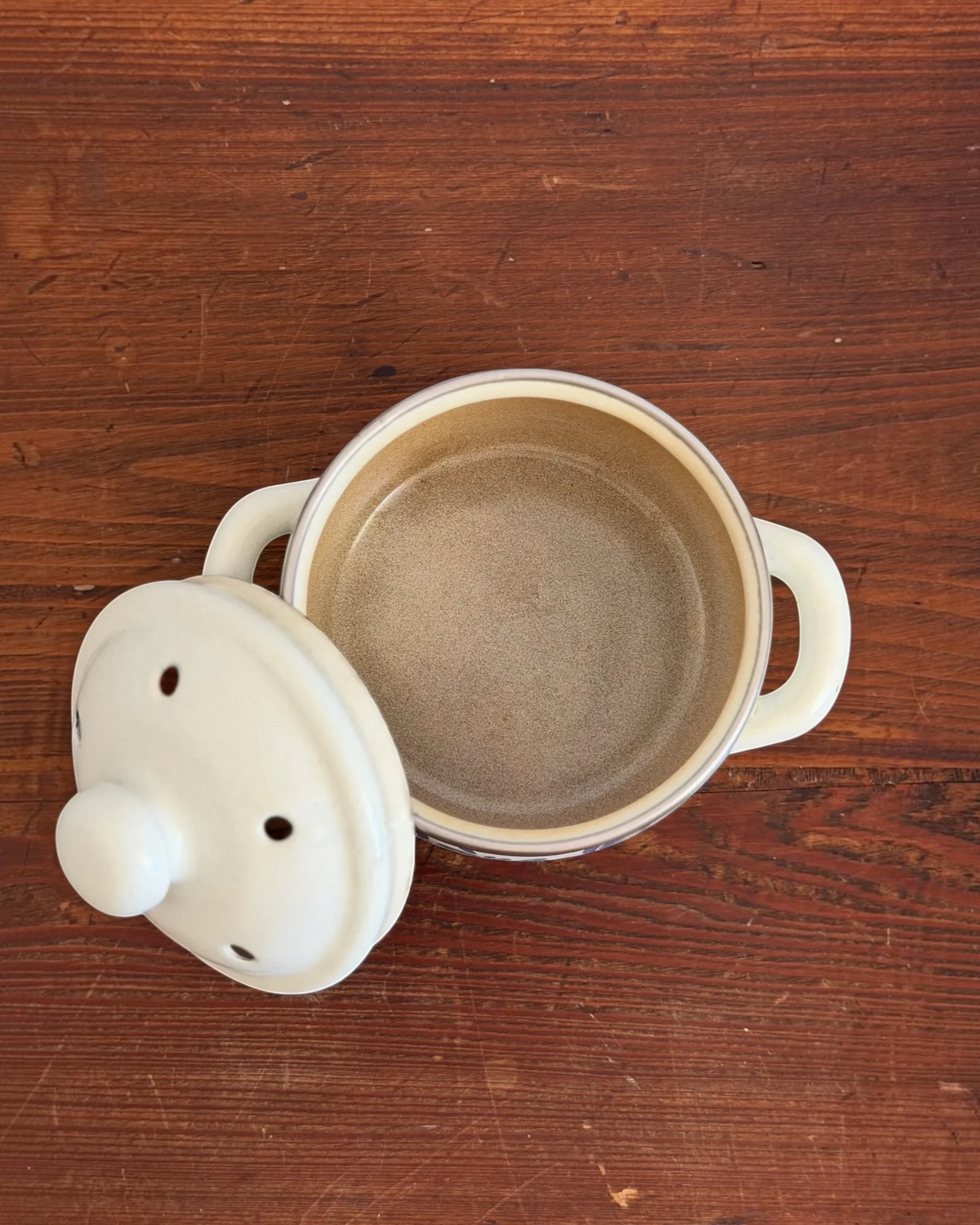 Homestyle Collective vintage blue and cream enamel simmer pot with a vented lid and speckled brown interior.