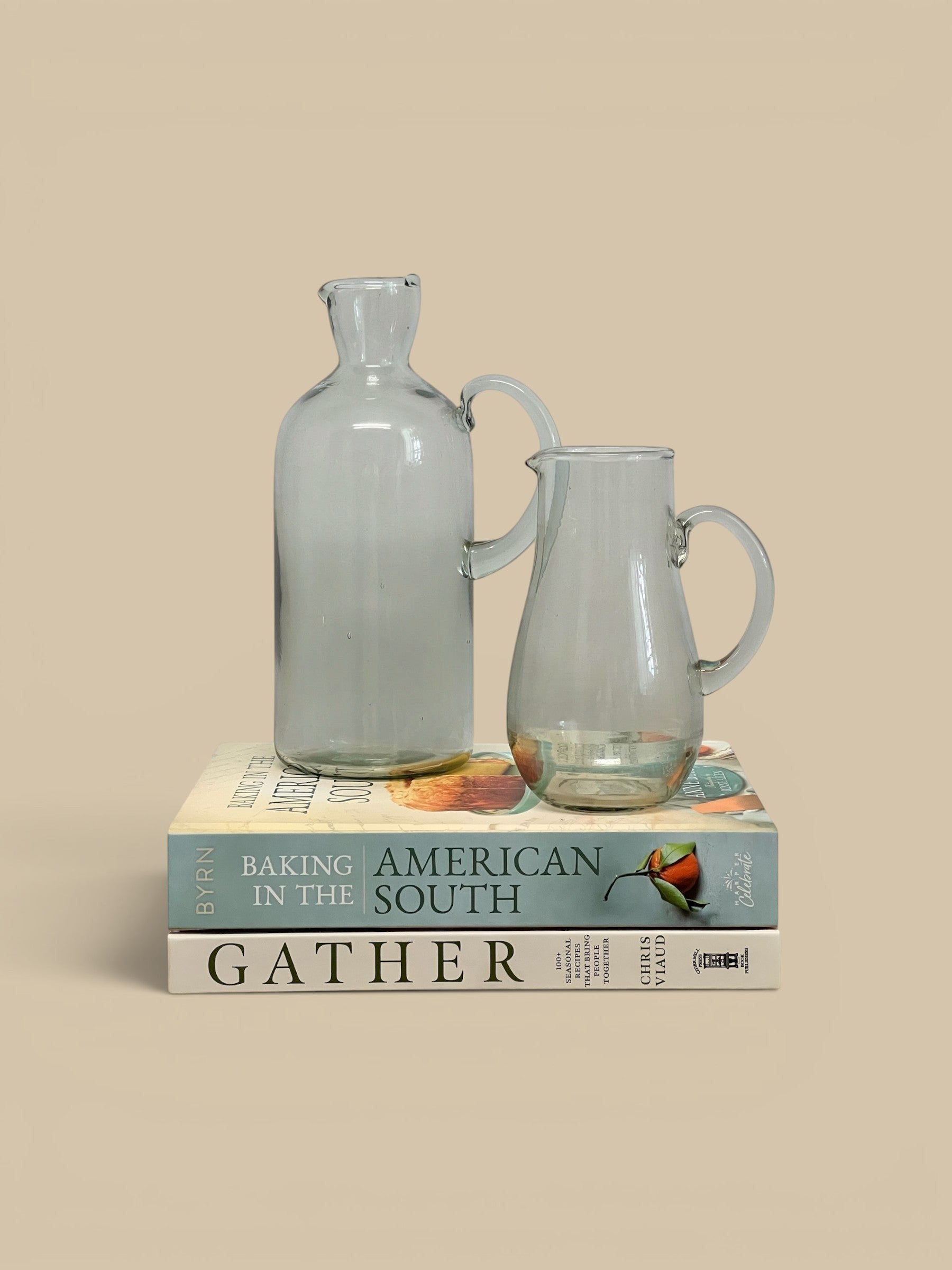 Homestyle Collective Ferra glass pitcher with handle and spout, clear, handcrafted artisanal detail, sculptural silhouette.