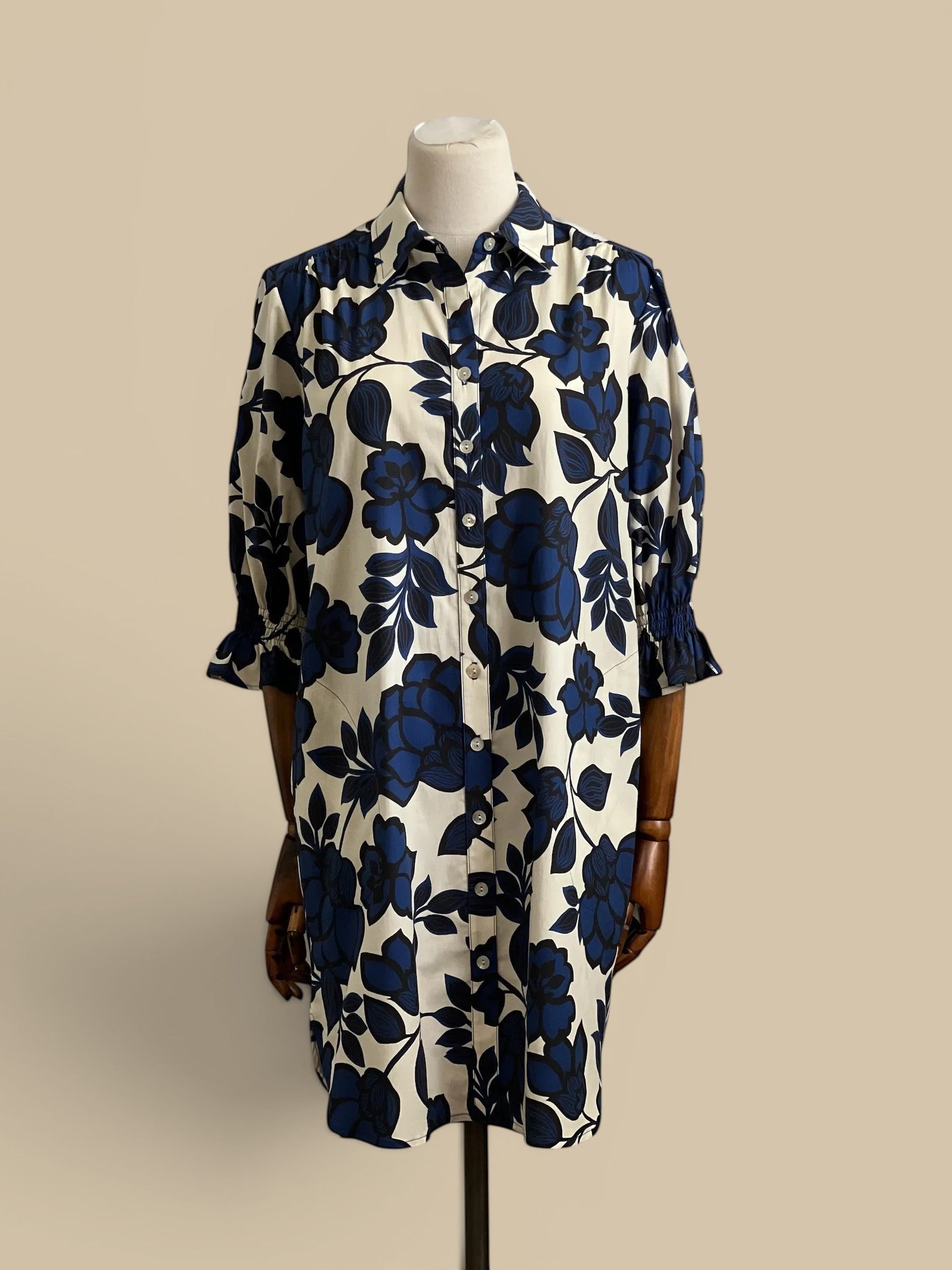Homestyle Collective Finley Miller dress in navy, white, and black floral print. Features puff sleeves, button front, and shirttail hem.
