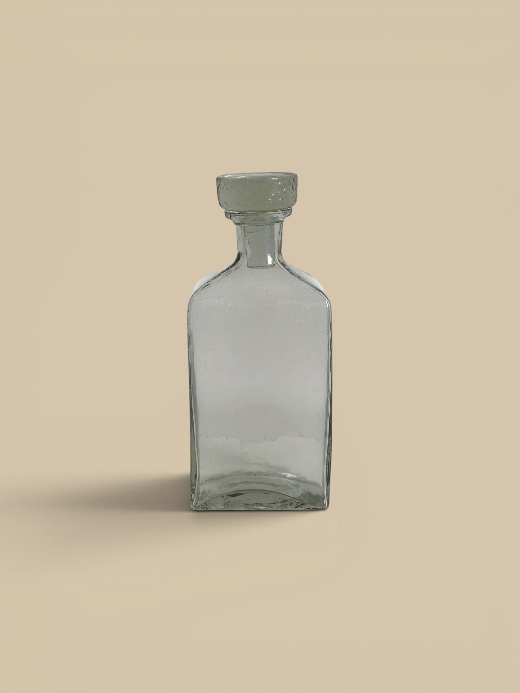 Homestyle Collective clear glass decanter with a textured stopper, ideal for spirits or decorative use.